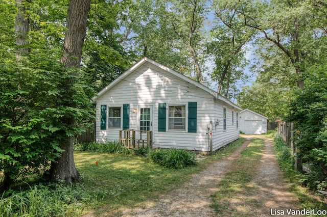 1819 Willis Ave NW, Grand Rapids, MI 49504 - view of front of house with dirt driveway, an outdoor structure, and a garage