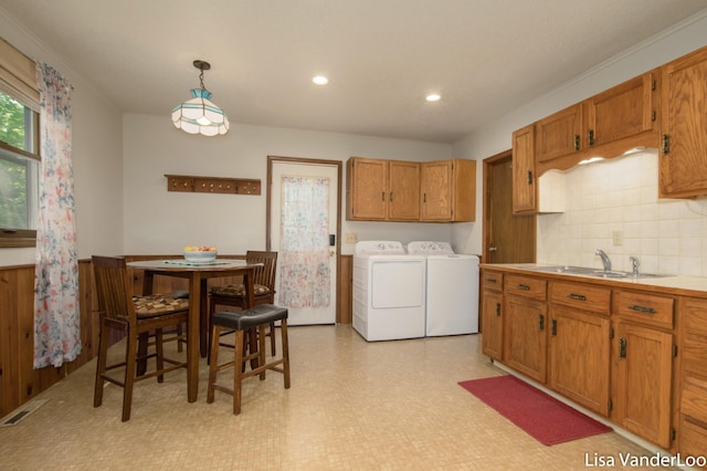 1819 Willis Ave NW, Grand Rapids, MI 49504 - kitchen featuring washing machine and clothes dryer, a sink, brown cabinetry, light floors, and recessed lighting