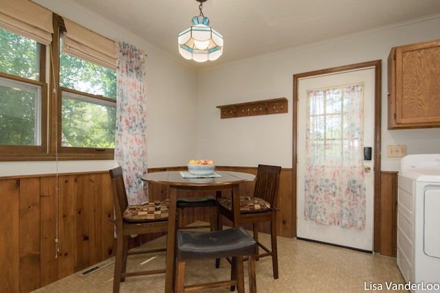 1819 Willis Ave NW, Grand Rapids, MI 49504 - dining room featuring washer / clothes dryer, a wainscoted wall, crown molding, and light flooring