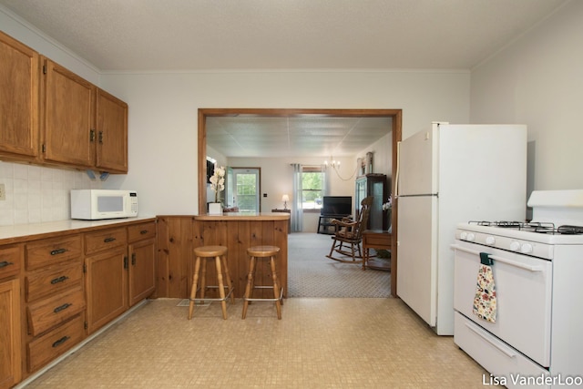 1819 Willis Ave NW, Grand Rapids, MI 49504 - kitchen with white appliances, brown cabinetry, light flooring, a peninsula, and crown molding