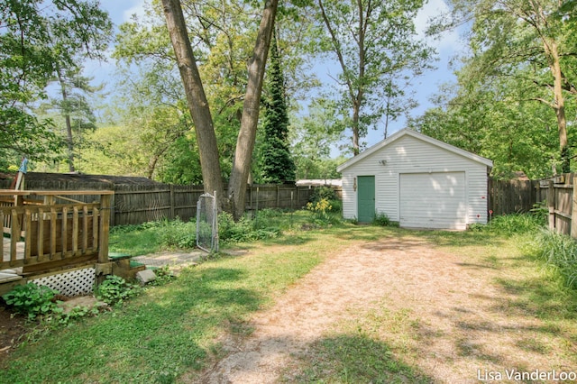1819 Willis Ave NW, Grand Rapids, MI 49504 - fenced backyard featuring a detached garage, an outbuilding, a deck, and driveway