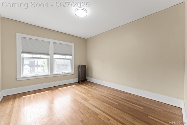 5302 Burns St, Detroit, MI 48213 - empty room featuring radiator heating unit, light wood-style flooring, and baseboards