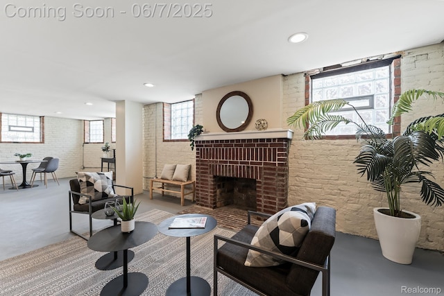5302 Burns St, Detroit, MI 48213 - living room featuring brick wall, concrete floors, a fireplace, and recessed lighting