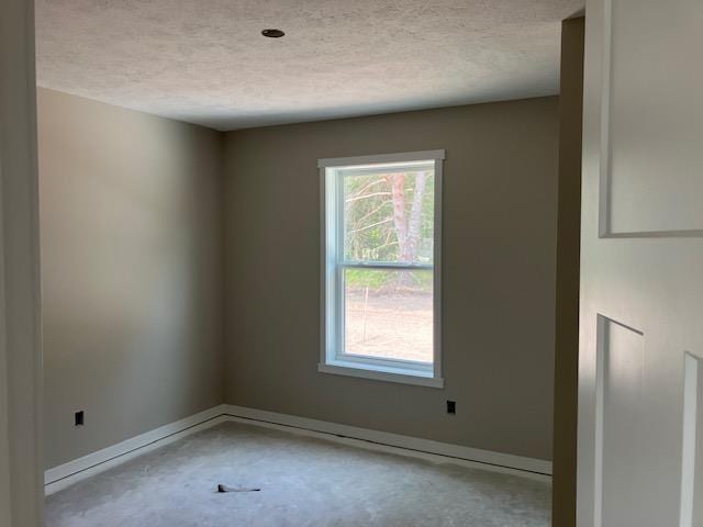F Walton Rd, Kingsley, MI 49649 - unfurnished room with concrete flooring, a textured ceiling, and baseboards