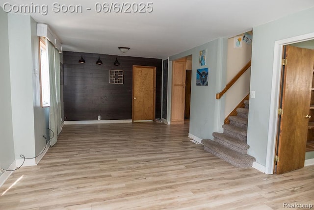 923 Stone St, Port Huron, MI 48060 - unfurnished room with stairs, light wood-type flooring, baseboards, and wood walls