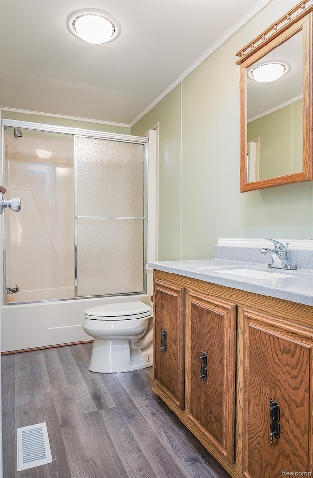 5730 Cavendar Dr, Mount Pleasant, MI 48883 - bathroom featuring toilet, vanity, crown molding, bath / shower combo with glass door, and wood finished floors