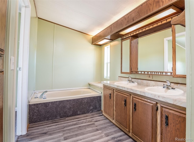 5730 Cavendar Dr, Mount Pleasant, MI 48883 - full bath featuring double vanity, a garden tub, and wood finished floors