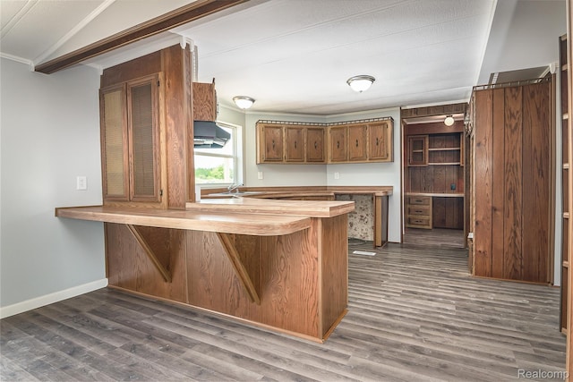 5730 Cavendar Dr, Mount Pleasant, MI 48883 - kitchen with a peninsula, dark wood finished floors, wooden counters, brown cabinets, and crown molding
