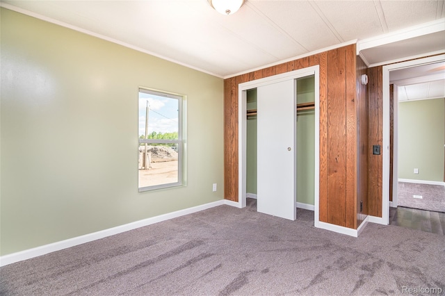 5730 Cavendar Dr, Mount Pleasant, MI 48883 - unfurnished bedroom with crown molding, carpet flooring, a closet, baseboards, and wood walls