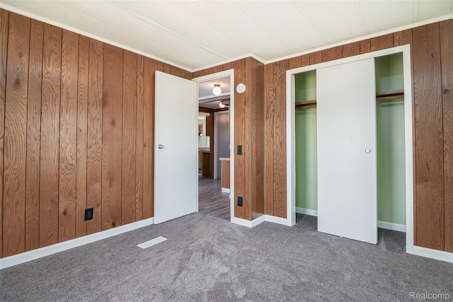 5730 Cavendar Dr, Mount Pleasant, MI 48883 - unfurnished bedroom featuring carpet, wood walls, a closet, ornamental molding, and baseboards