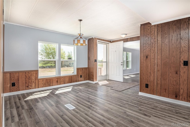 5730 Cavendar Dr, Mount Pleasant, MI 48883 - unfurnished dining area featuring wooden walls, a wainscoted wall, wood finished floors, and baseboards