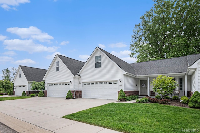 816 Nelsons Ridge Dr, Howell, MI 48843 - traditional-style house featuring a front yard, driveway, brick siding, roof with shingles, and an attached garage