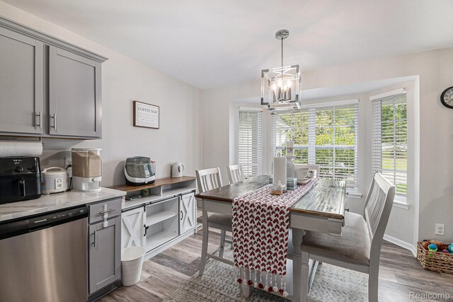 816 Nelsons Ridge Dr, Howell, MI 48843 - dining space with wood finished floors, a chandelier, and baseboards