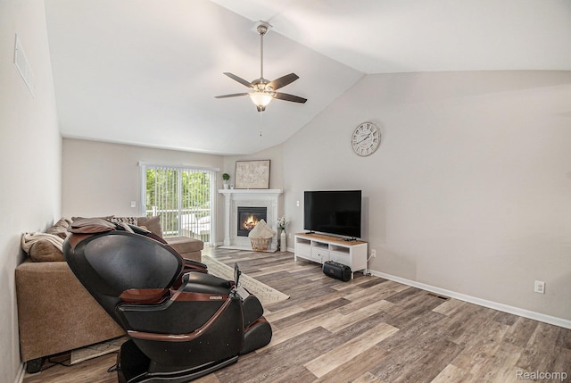 816 Nelsons Ridge Dr, Howell, MI 48843 - living area with lofted ceiling, a glass covered fireplace, wood finished floors, and ceiling fan