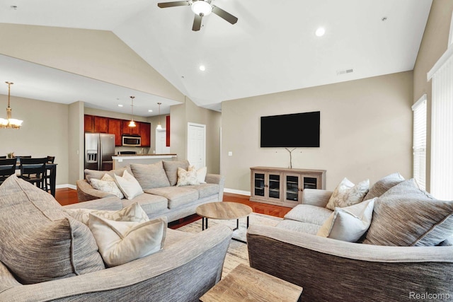 48888 Amanda Ln, Shelby Twp, MI 48317 - living area with vaulted ceiling, a chandelier, a ceiling fan, light wood finished floors, and baseboards