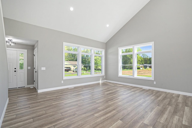 233 Markus Glen Dr, Plainwell, MI 49080 - unfurnished living room featuring light wood finished floors, high vaulted ceiling, baseboards, and recessed lighting