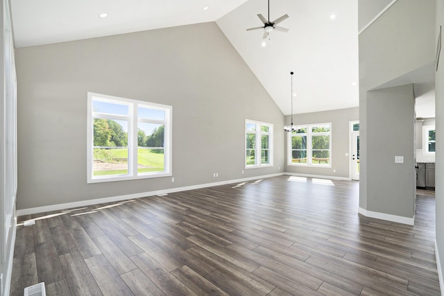 233 Markus Glen Dr, Plainwell, MI 49080 - unfurnished living room featuring high vaulted ceiling, ceiling fan, dark wood-style floors, baseboards, and a chandelier