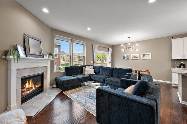 2765 Polson St, Ann Arbor, MI 48105 - living room featuring a chandelier, a tile fireplace, recessed lighting, dark wood-type flooring, and baseboards