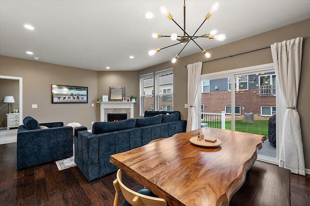 2765 Polson St, Ann Arbor, MI 48105 - dining space with dark wood-type flooring, a chandelier, recessed lighting, and a warm lit fireplace