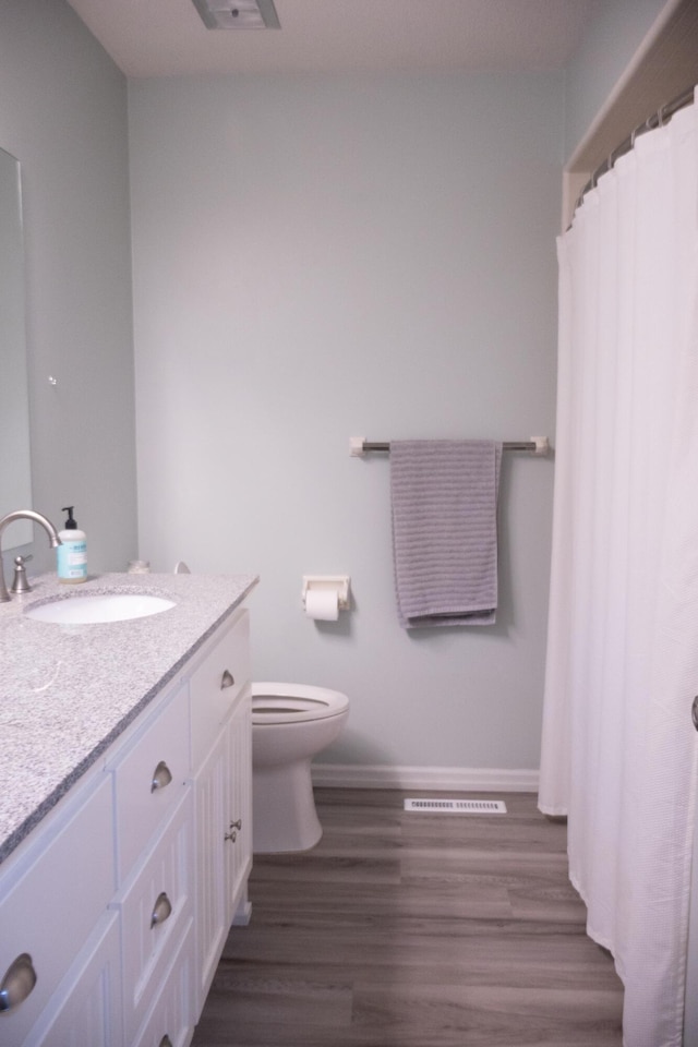 4873 Terrace Ln, Saint Joseph, MI 49085 - bathroom featuring vanity, toilet, wood finished floors, and baseboards