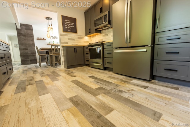 343 Beaupre Ave, Grosse Pointe Farms, MI 48236 - kitchen with appliances with stainless steel finishes, light wood-style floors, and decorative backsplash