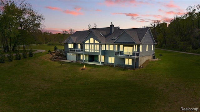 12150 Shaffer Rd, Davisburg, MI 48350 - rear view of house with a lawn, a chimney, an attached garage, and a deck
