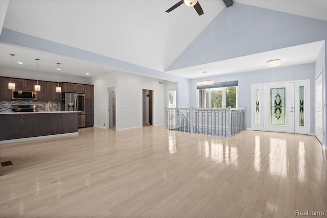 12150 Shaffer Rd, Davisburg, MI 48350 - unfurnished living room featuring high vaulted ceiling, a ceiling fan, light wood-type flooring, a sink, and recessed lighting