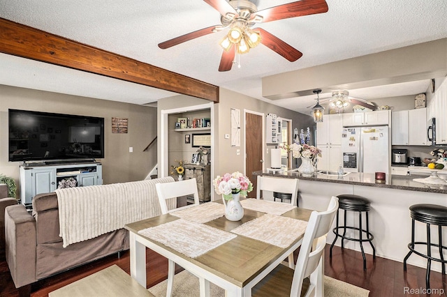 11135 Maple Ridge Way, Roscommon, MI 48653 - dining area with a ceiling fan, dark wood-type flooring, a textured ceiling, and beamed ceiling