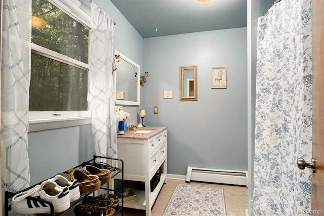 11135 Maple Ridge Way, Roscommon, MI 48653 - full bathroom featuring a baseboard radiator, vanity, tile patterned floors, and baseboards