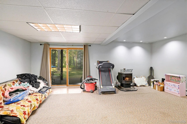 11135 Maple Ridge Way, Roscommon, MI 48653 - rec room featuring a wood stove, a paneled ceiling, carpet, and recessed lighting