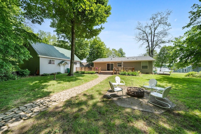 61738 Lake View Dr, Cassopolis, MI 49031 - view of grassy yard with a fire pit, a wooden deck, and a patio