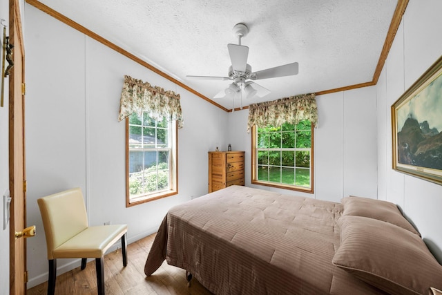 61738 Lake View Dr, Cassopolis, MI 49031 - bedroom with ornamental molding, light wood-style flooring, ceiling fan, a textured ceiling, and baseboards