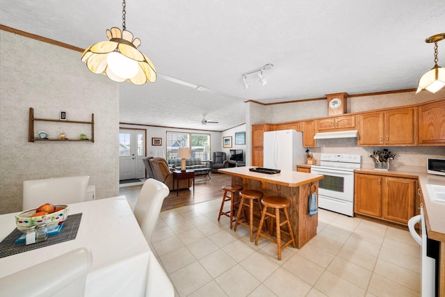 61738 Lake View Dr, Cassopolis, MI 49031 - kitchen featuring white appliances, under cabinet range hood, a textured ceiling, light countertops, and a center island