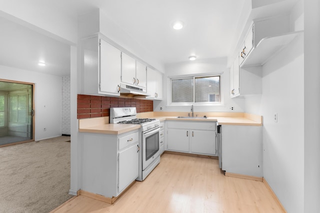29848 Rambling Rd, Southfield, MI 48076 - kitchen with white range with gas cooktop, a sink, under cabinet range hood, light countertops, and white cabinets
