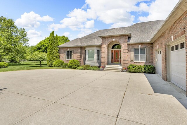 10575 Darrel Dr, Hanover, MI 49241 - view of front of home featuring brick siding, a shingled roof, concrete driveway, and an attached garage
