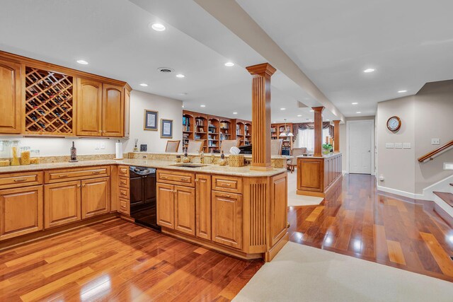 10575 Darrel Dr, Hanover, MI 49241 - kitchen featuring ornate columns, dishwasher, a peninsula, light wood-style flooring, and a sink