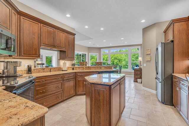 10575 Darrel Dr, Hanover, MI 49241 - kitchen with stainless steel appliances, tasteful backsplash, a kitchen island, recessed lighting, and light stone counters