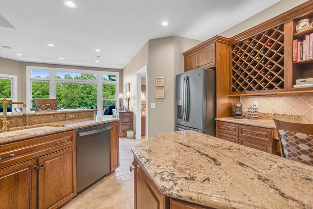 10575 Darrel Dr, Hanover, MI 49241 - kitchen featuring appliances with stainless steel finishes, light stone counters, recessed lighting, tasteful backsplash, and a sink