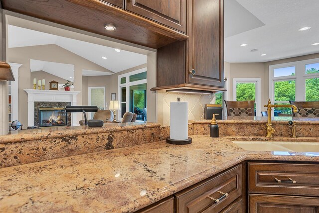 10575 Darrel Dr, Hanover, MI 49241 - kitchen featuring a fireplace, a sink, light stone countertops, recessed lighting, and tasteful backsplash
