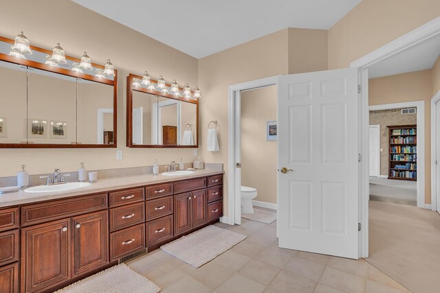 10575 Darrel Dr, Hanover, MI 49241 - full bathroom with double vanity, toilet, and baseboards