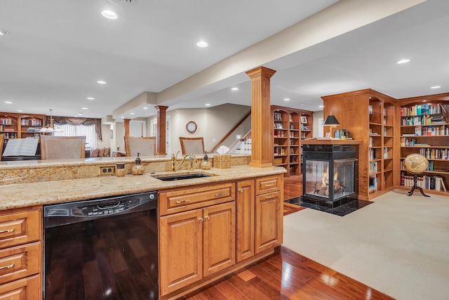 10575 Darrel Dr, Hanover, MI 49241 - kitchen with dishwasher, a sink, ornate columns, a multi sided fireplace, and dark wood-type flooring