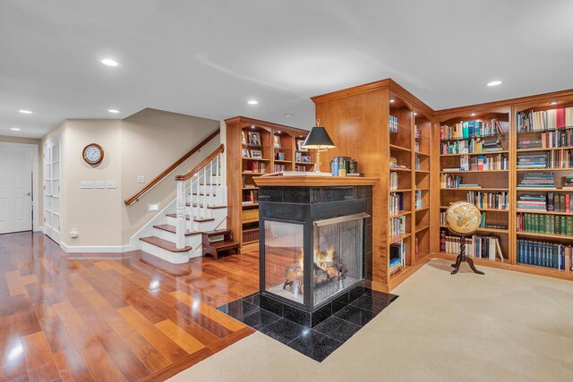 10575 Darrel Dr, Hanover, MI 49241 - living area featuring a tiled fireplace, wood finished floors, recessed lighting, stairway, and baseboards