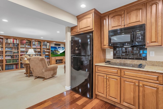 10575 Darrel Dr, Hanover, MI 49241 - kitchen with black appliances, dark wood-style flooring, light stone counters, brown cabinets, and recessed lighting