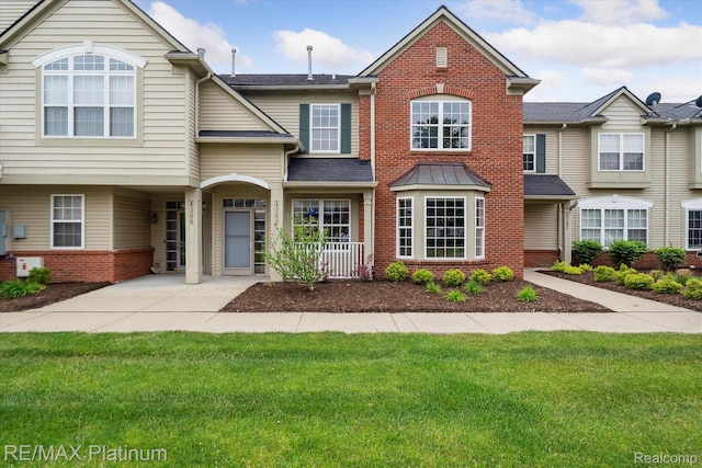 4300 Hampton Ridge Blvd, Howell, MI 48843 - townhome / multi-family property with brick siding, a front yard, and a shingled roof