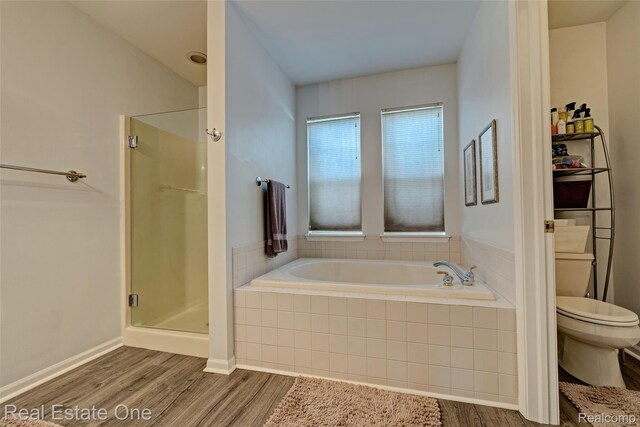 2338 Malena Ln, Oxford, MI 48371 - bathroom featuring toilet, wood finished floors, a garden tub, and a stall shower