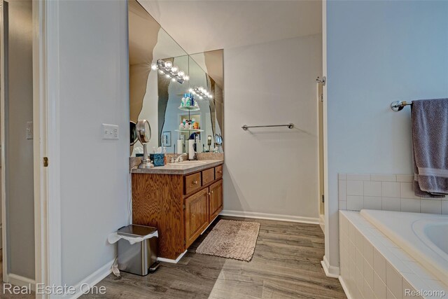 2338 Malena Ln, Oxford, MI 48371 - full bath featuring vanity, a bath, wood finished floors, and baseboards