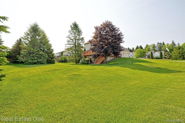 2338 Malena Ln, Oxford, MI 48371 - view of green lawn with stairs, an attached garage, and a deck