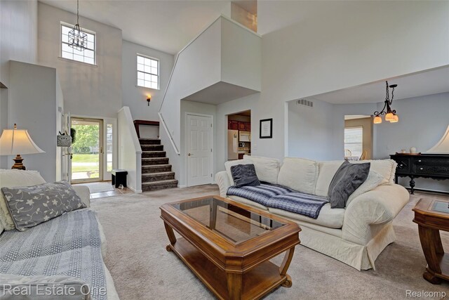 2338 Malena Ln, Oxford, MI 48371 - carpeted living room with a chandelier, a high ceiling, and stairs