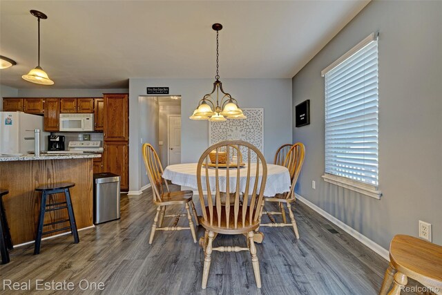 2338 Malena Ln, Oxford, MI 48371 - dining area featuring a chandelier, dark wood-style flooring, and baseboards