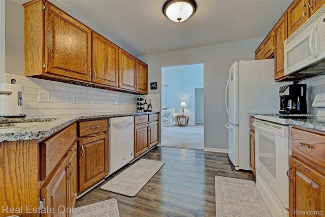 2338 Malena Ln, Oxford, MI 48371 - kitchen featuring white appliances, decorative backsplash, brown cabinetry, dark wood finished floors, and light stone counters